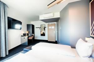 ein Hotelzimmer mit einem Bett und einem TV in der Unterkunft B&B Hotel Böblingen in Böblingen