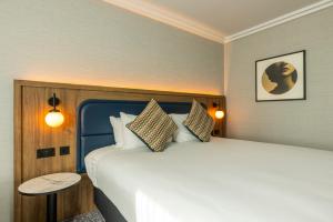 um quarto com uma cama grande e uma mesa em Crowne Plaza Manchester Airport, an IHG Hotel em Hale