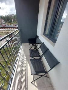 two chairs sitting on a balcony next to a window at Golden Apartman in Zlatibor +2 photos
