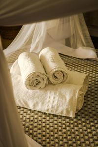 two rolls of paper towels sitting on top of a bed at Pousada Jacarandá by Rivaj in Trancoso