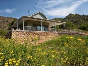 a house on the side of a hill with flowers at Latjeskloof Accommodation in Citrusdal