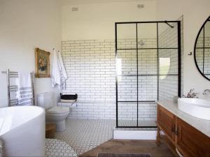 ein Badezimmer mit einer Badewanne, einem WC und einem Waschbecken in der Unterkunft Latjeskloof Accommodation in Citrusdal