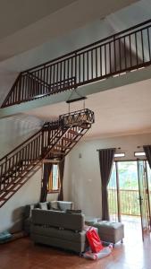 a living room with a spiral staircase in a house at Villa Bumisoka in Purwakarta