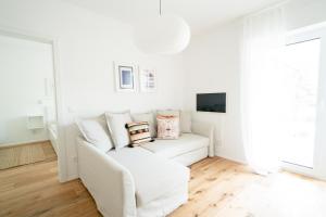 a white living room with a white couch and a tv at Apartment Seekind by Cosy Homes in Reifnitz