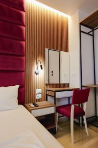 a bedroom with a desk and a bed and a red chair at Vila Shpetimi in Ksamil