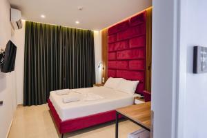 a bedroom with a large bed with a red headboard at Vila Shpetimi in Ksamil