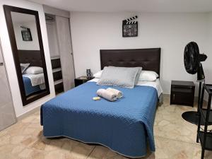 1 dormitorio con 1 cama azul y 2 toallas en Hermoso apartaestudio en el corazón de laureles, en Medellín