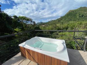 a jacuzzi tub on a balcony with a view at GLAMPING EL PARAÍSO in Sasaima