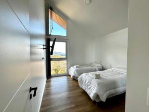 2 camas en una habitación con ventana en Starigrad en Ushuaia