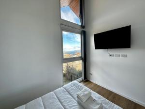 a bedroom with a tv and a bed and a window at Starigrad in Ushuaia
