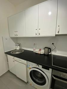 a kitchen with a sink and a washing machine at Pika Hostel in Prizren +3 photos