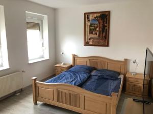 1 dormitorio con cama de madera con sábanas azules en Ferienhaus Staßfurt, en Staßfurt