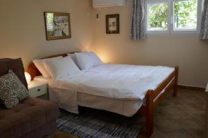 a bedroom with a bed and a couch and a window at EcoHouse Risan Studio in Risan