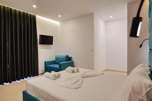 a bedroom with a bed and a blue chair at Vila Shpetimi in Ksamil