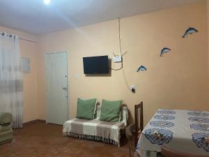 a bedroom with a bed and a tv on the wall at Casa da vovó Marta in Itanhaém