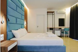 a bedroom with a large bed with a blue headboard at Vila Shpetimi in Ksamil