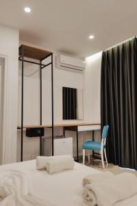 a bedroom with a bed and a blue chair at Vila Shpetimi in Ksamil
