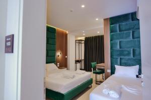 a hotel room with two beds and a table at Vila Shpetimi in Ksamil