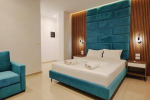 a bedroom with a large bed and a blue chair at Vila Shpetimi in Ksamil