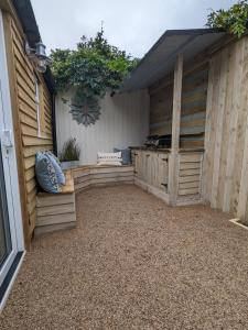 an outdoor patio with a building with wooden walls at La Cachette in Blackpool