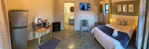 a room with a bed and a refrigerator in it at River View in Potchefstroom