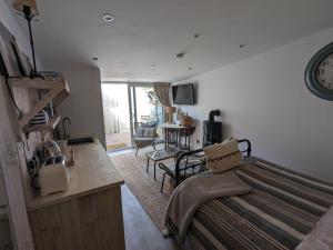 1 dormitorio con 1 cama y sala de estar con mesa en La Cachette en Blackpool