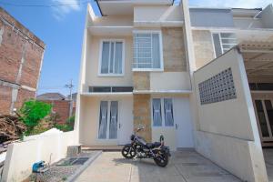 巴图Villa Mulyo E4 by Sans Villa的一辆摩托车停在房子前面