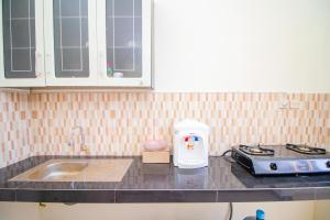 a kitchen counter with a stove and a sink at Villa Mulyo E4 by Sans Villa in Batu