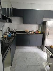 a kitchen with black cabinets and a tiled floor at Casa no coração de Recife para Carnaval in Recife