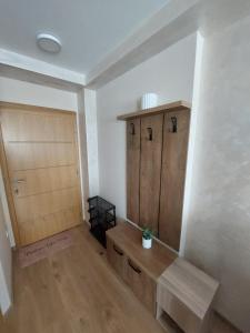a room with a wooden bench and a door at Golden Apartman in Zlatibor