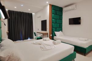 a hotel room with two beds and a television at Vila Shpetimi in Ksamil