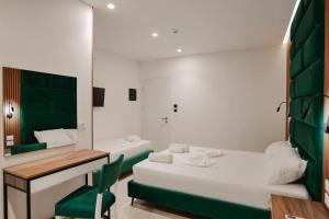 a room with two beds and a desk and a mirror at Vila Shpetimi in Ksamil