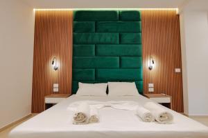 a bedroom with a bed with a green headboard at Vila Shpetimi in Ksamil