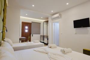 a hotel room with two beds and a flat screen tv at Vila Shpetimi in Ksamil