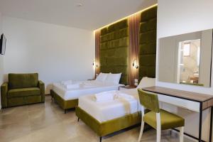 a hotel room with two beds and a desk at Vila Shpetimi in Ksamil