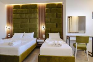 a bedroom with two beds and a desk and a chair at Vila Shpetimi in Ksamil