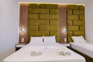 two beds in a room with towels on them at Vila Shpetimi in Ksamil