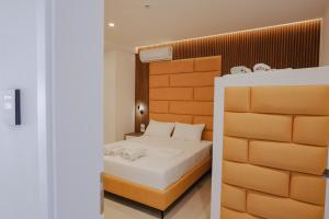a bedroom with a bed with white sheets at Vila Shpetimi in Ksamil