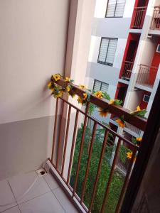 a balcony with flowers on the railing of a building at My Bubble Affordable Staycation in Marilao