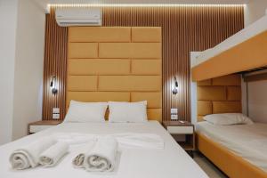 a hotel room with two beds with towels on them at Vila Shpetimi in Ksamil