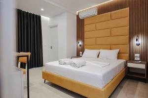 a bedroom with a large bed with a wooden headboard at Vila Shpetimi in Ksamil