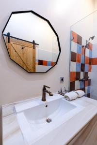 La salle de bains est pourvue d'un lavabo et d'un grand miroir. dans l'établissement BELVA huis, à Bogor