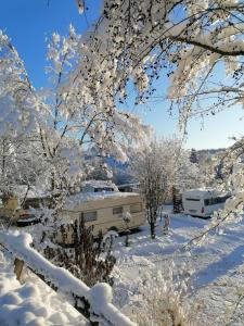 a snow covered yard with two rvs in the background at Campingplatz Am Bärenbache in Braunlage