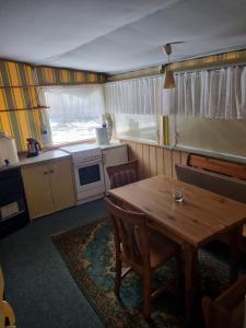 a kitchen with a wooden table and a table and chairs at Campingplatz Am Bärenbache in Braunlage