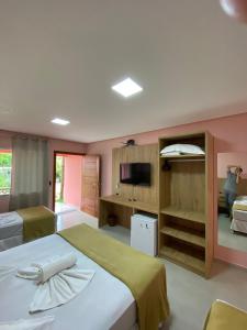 1 dormitorio con 1 cama grande y TV en Pousada Baía dos Açores, en Penha