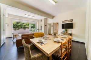 une salle à manger et un salon avec une table et des chaises dans l'établissement Villa et grand jacuzzi six personnes, en pleine nature, à Saint-Joseph