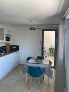 une cuisine avec une table et des chaises dans une pièce dans l'établissement Studio Benvengudo Port La Ciotat - Appartement et parking, à La Ciotat