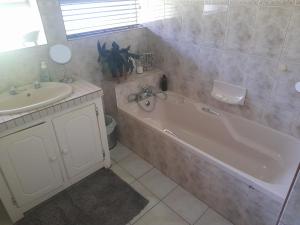 y baño con bañera y lavamanos. en Angel 8 AirBnB Family Apartment en Robertson