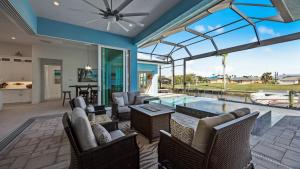 sala de estar con piscina y ventana grande en BRAND NEW! Direct Sailboat Access, Breathtaking Saltwater Pool - Villa Blue Lagoon - Roelens, en Cabo Coral