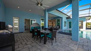comedor con mesa y sillas junto a la piscina en BRAND NEW! Direct Sailboat Access, Breathtaking Saltwater Pool - Villa Blue Lagoon - Roelens, en Cabo Coral